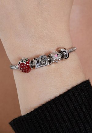 Silver charm bracelet featuring a red enamel strawberry, silver camera, and heart-accent charm, with a textured chain and shiny metal accents.