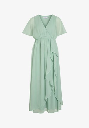 Šviesiai žalia, trumpomis rankovėmis, V-formos apykakle įvyniota suknelė su susiraukšlėjusiu liemeniu ir krentanančiu volanu iš vienos pusės, midi ilgio, lengvas audinys.