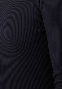 Top a manica lunga a coste di colore blu navy, caratterizzato da una vestibilità aderente e una texture morbida, con strisce verticali e scollatura a girocollo.