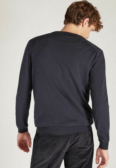 Marineblaue Langarm-Sweatshirt, runder Ausschnitt, gerippte Bündchen und Saum, hergestellt aus einem weichen Stoff mit glatter Textur. Getragen mit Cordhosen.