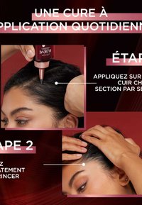 Applicateur de traitement capillaire avec une pointe effilée, boîtier en plastique rouge foncé et poignée texturée. Montre l'application sur le cuir chevelu par sections.