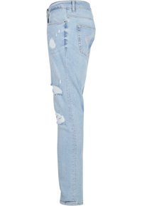 Jeans de mezclilla azul claro con corte ajustado, que presentan detalles desgastados y áreas rasgadas en la parte delantera. Diseño clásico de cinco bolsillos.