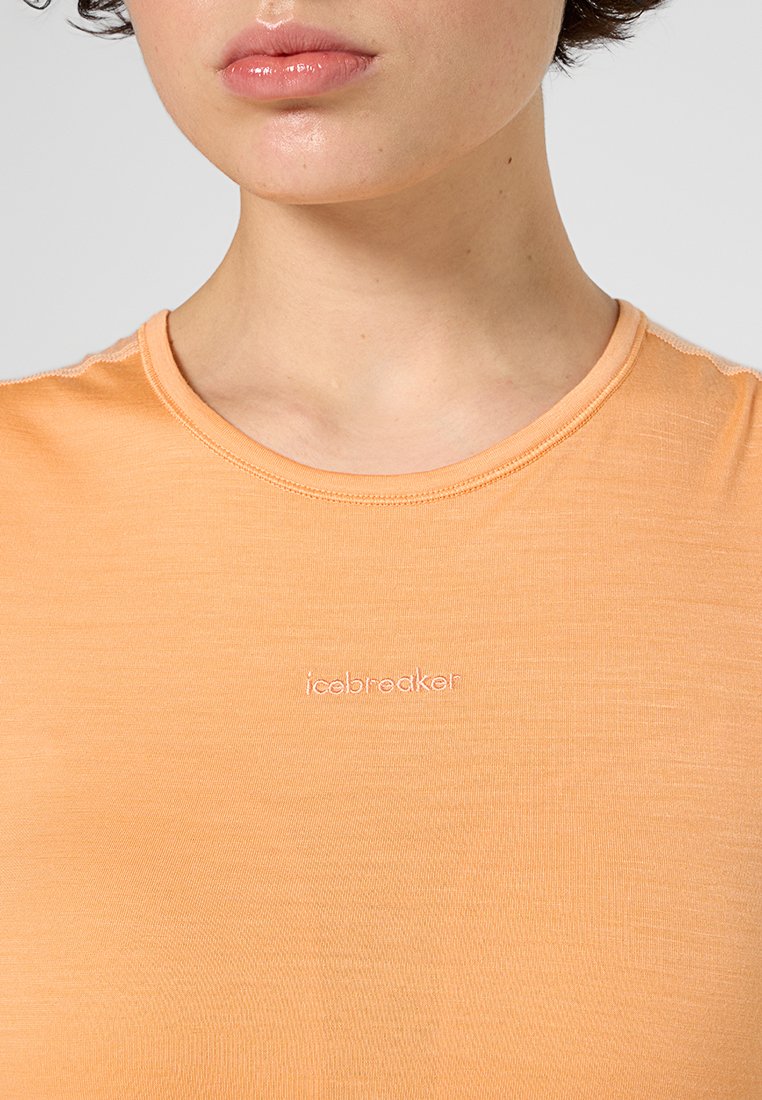 T-shirta w kolorze brzoskwiniowym, z krótkim rękawem, wykonana z miękkiego materiału. Posiada okrągły dekolt oraz subtelne logo "icebreaker" z przodu.