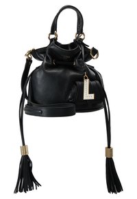 Sac seau en cuir noir avec quincaillerie dorée, anse supérieure, bandoulière réglable et pompons décoratifs. Comprend un charm en lettres blanches.