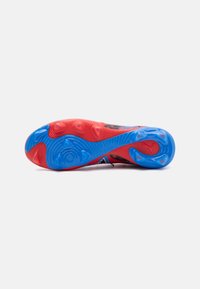 Soletta di scarpa sportiva con un design in gomma rossa e blu, testurizzata per la trazione, con una forma arrotondata e motivi distintivi.
