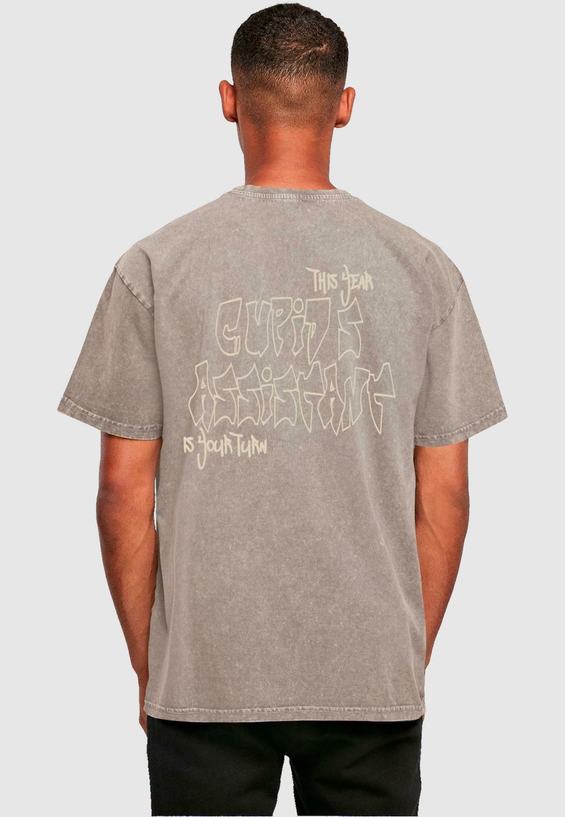 Grå kortærmet t-shirt med en afslappet pasform. Har et abstrakt tekstdesign i lysere farve på ryggen. Lavet af bomuldsstof med en blød tekstur.