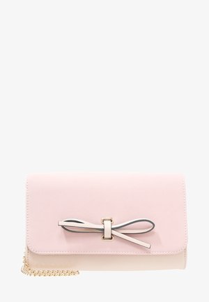 Prostokątna, bladoróżowa kopertówka z cienką kokardką na przedniej klapie i częściowo widocznym złotym łańcuszkiem na ramię.