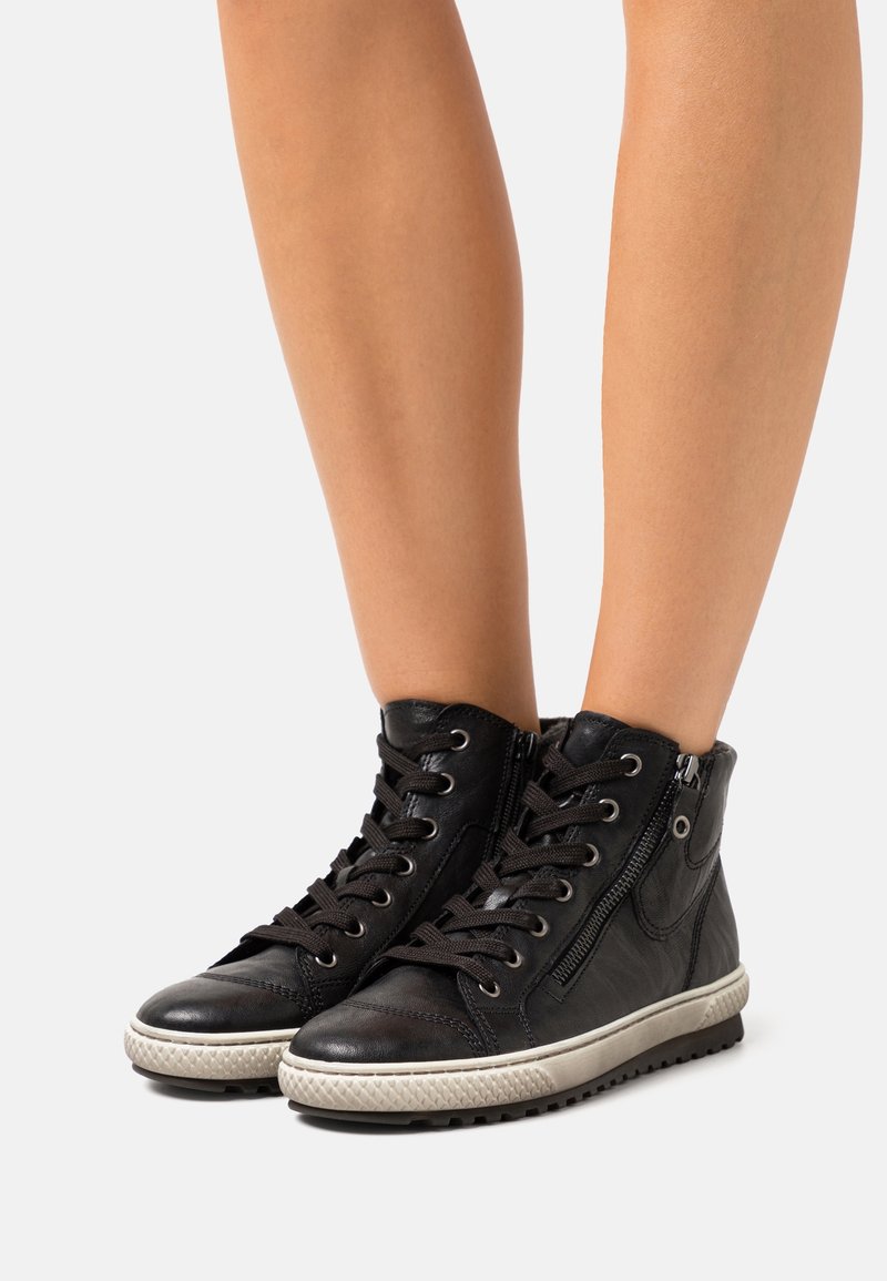 Baskets montantes en cuir noir avec lacets sur le devant, fermeture éclair sur le côté, bout rond et semelle en caoutchouc texturée avec des accents de motif en relief.