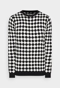 Černobílý vzorovaný svetr s diamantovým vzorem, žebrovaným výstřihem a manžetami, vyrobený z měkkého, texturovaného pleteného materiálu.