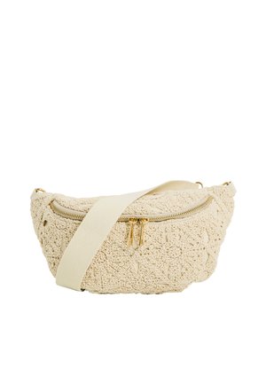 Bolso bandolera beige texturizado con patrones de encaje floral, cremallera dorada y correa ancha de color crema.