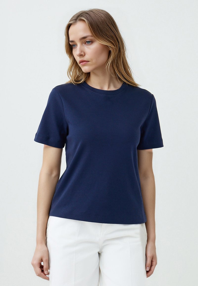 T-shirt in cotone blu navy con maniche corte, scollatura rotonda e taglio dritto. Texture liscia; nessun motivo o accento visibile.