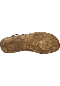 Pohja kengästä, joka on valmistettu textured ruskeasta kumista, jossa on kukkakuosi, jossa on suuria ja pieniä kukkasuunnitteluja ympäriinsä.