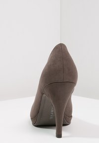 Bruna mocka högklackade pumps med spetsig tå, smal klack och slät yta. Har subtil sömnad längs bakisonen.