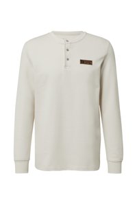 Langarm henley shirt in off-white katoen. Heeft drie knopen bij de hals, ribgebreide manchetten en een bruine logopatch op de borst.