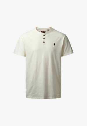 Tejfehér, rövid ujjú pamut póló, három gombos gallérral és kisebb fekete logóval a mellkasán. Sima textúra.