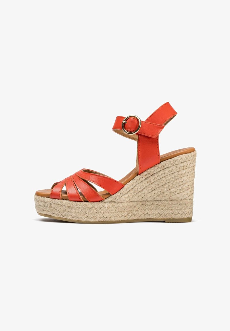 Sandale à talon compensé en cuir orange avec une semelle en jute tressé. Dotée de brides entrecroisées, d'une bride au niveau de la cheville avec boucle en métal et d'une finition texturée.