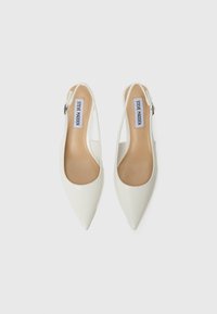 Valkoiset kärkiosat slingback-kengät, jotka on valmistettu sileästä synteettisestä materiaalista. Kengissä on matala korko ja säädettävä nilkk straps.