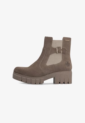 Bottine taupe avec semelle épaisse crantée, boucle latérale et panneau en mesh beige, marquée d’un petit logo près du talon.