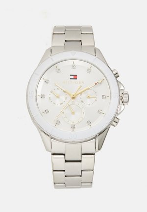 Montre en acier inoxydable argenté avec un cadran blanc, des accents dorés, trois sous-cadrans et des marqueurs en cristal. Elle dispose d'un bracelet à maillons et d'une finition polie.