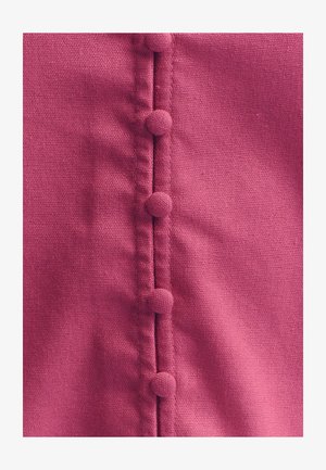 Fuchsia stof met een gladde textuur, voorzien van een rij ronde, gestructureerde knopen aan één kant en subtiele stikdetails.