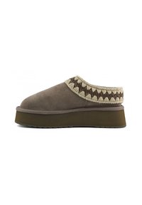 Scarpa slip-on in suede marrone con suola spessa, che presenta un'accademia intrecciata testurizzata lungo il bordo superiore. Design della punta piatta e arrotondata.