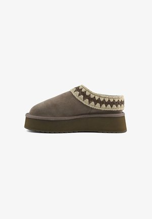 Scarpa slip-on in suede marrone con suola spessa, che presenta un'accademia intrecciata testurizzata lungo il bordo superiore. Design della punta piatta e arrotondata.
