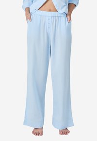 Lichtblauwe pyjamabroek met een elastische tailleband, zijzakken en een ontspannen pasvorm. Gemaakt van een zachte stof met een gladde textuur.