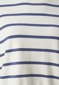 Randig tröja med vit bas och marinblå horisontella ränder. Tyget ser mjukt ut med en strukturerad yta. Rund halsringning.