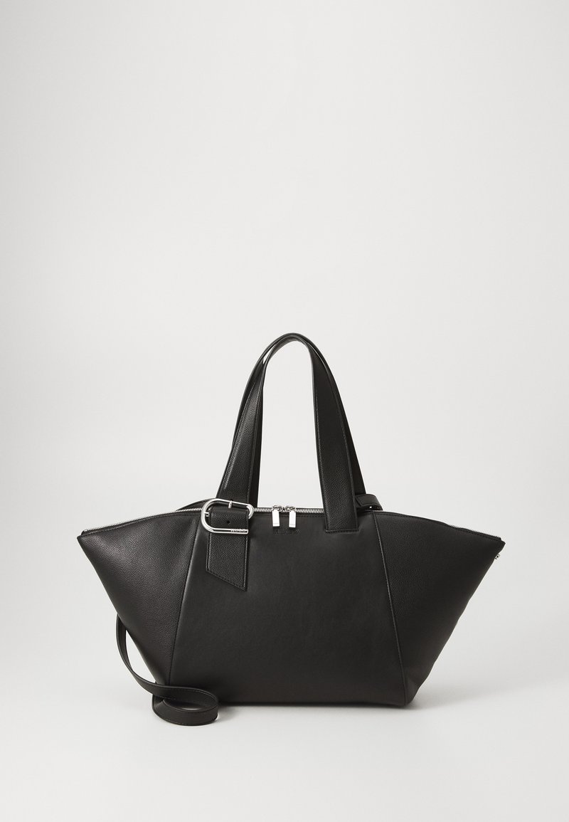 Black leather tote bag with angular shape, dual handles, adjustable strap, and silver hardware. Textured finish with side accents.