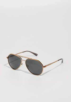 Aviator-Sonnenbrille mit goldfarbenem Metallrahmen, dunkelgrauen Gläsern und strukturierten schwarzen Tempelspitzen. Mit Nasenpads für zusätzlichen Komfort.