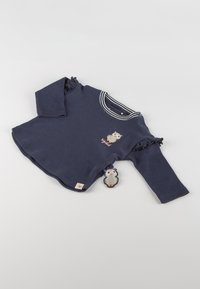 Navy blue long-sleeve shirt with white striped collar, ruffled sleeves, owl graphic, and tag featuring a cartoon owl accent.