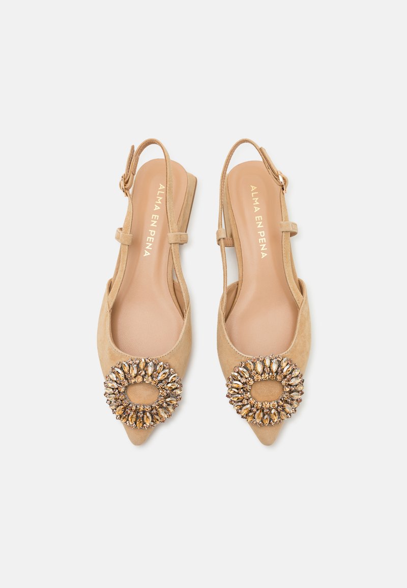 Zapatos slingback de ante beige con punta afilada y una decoración de strass redonda. Cuentan con un tacón bajo y una correa ajustable.