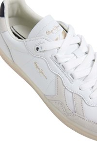 Baskets en cuir blanc avec lacets blancs, accents en daim beige et marquage "Pepe Jeans London" sur la languette et le côté.