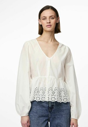 Blusa de algodón blanca con escote en V, cierre de botones al frente y mangas abullonadas. El dobladillo presenta detalles bordados en forma de ojal con un patrón floral.