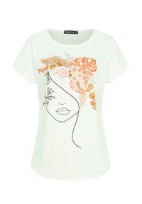 T-shirt blanc à manches courtes présentant un dessin de visage en ligne noire orné d'illustrations florales et feuillues dans des tons terreux.