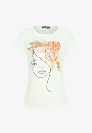 Balta trumpa rankovėmis marškinėliai, krūtinėje turintys juodą linijinę piešinio veido versiją, papuoštą žydinčių gėlių ir lapų iliustracijomis žemės tonais.