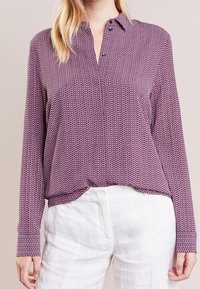 Camicia a maniche lunghe con bottoni in bordeaux con motivo a zigzag, realizzata in un tessuto liscio, con colletto a punta e orlo curvo.