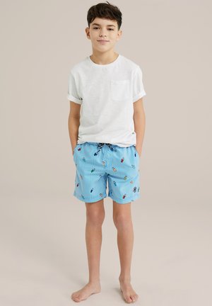 Hvid kortærmet t-shirt med lomme, parret med blå stribede badebukser med farverige is og isvaffel mønstre.