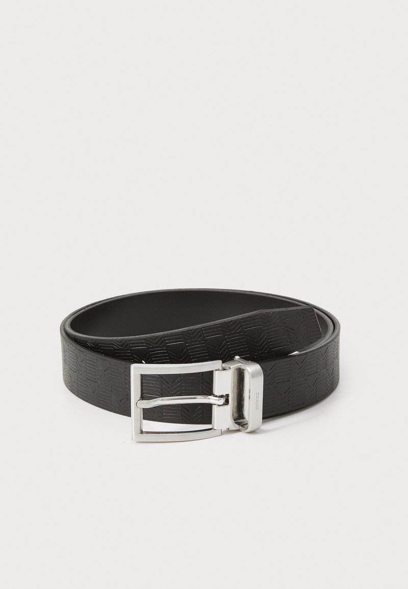 Cinturón de cuero negro con un patrón texturizado en forma de chevron, rematado con una hebilla de metal plateada y brillante. Forro interior suave.