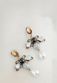 Gold-toned earrings shaped like bees, featuring black and white polka dot detailing, gemstone accents, and teardrop pearls.