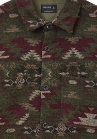 Camicia abbottonata con motivi geometrici verdi, burgundy e beige, dotata di colletto e di un'etichetta visibile che mostra "Calliope L Comfort Fit."