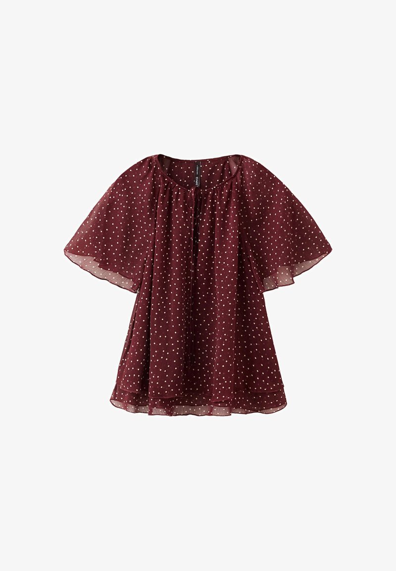 Blouse bordeaux transparente à pois blancs, coupe ample, manches volantées et encolure arrondie avec un petit lien sur le devant.