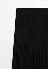 Tissu tricoté côtelé noir avec une large ceinture, présenté à plat sur fond blanc.