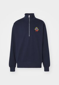 Navy blue quarter-zip pullover with a high collar and embroidered multicolor crest logo on the left chest.