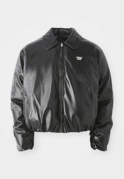 Veste bomber en similicuir noir avec fermeture éclair à l'avant, patch logo sur la poitrine, ourlet et poignets élastiques, et col classique sur fond blanc.