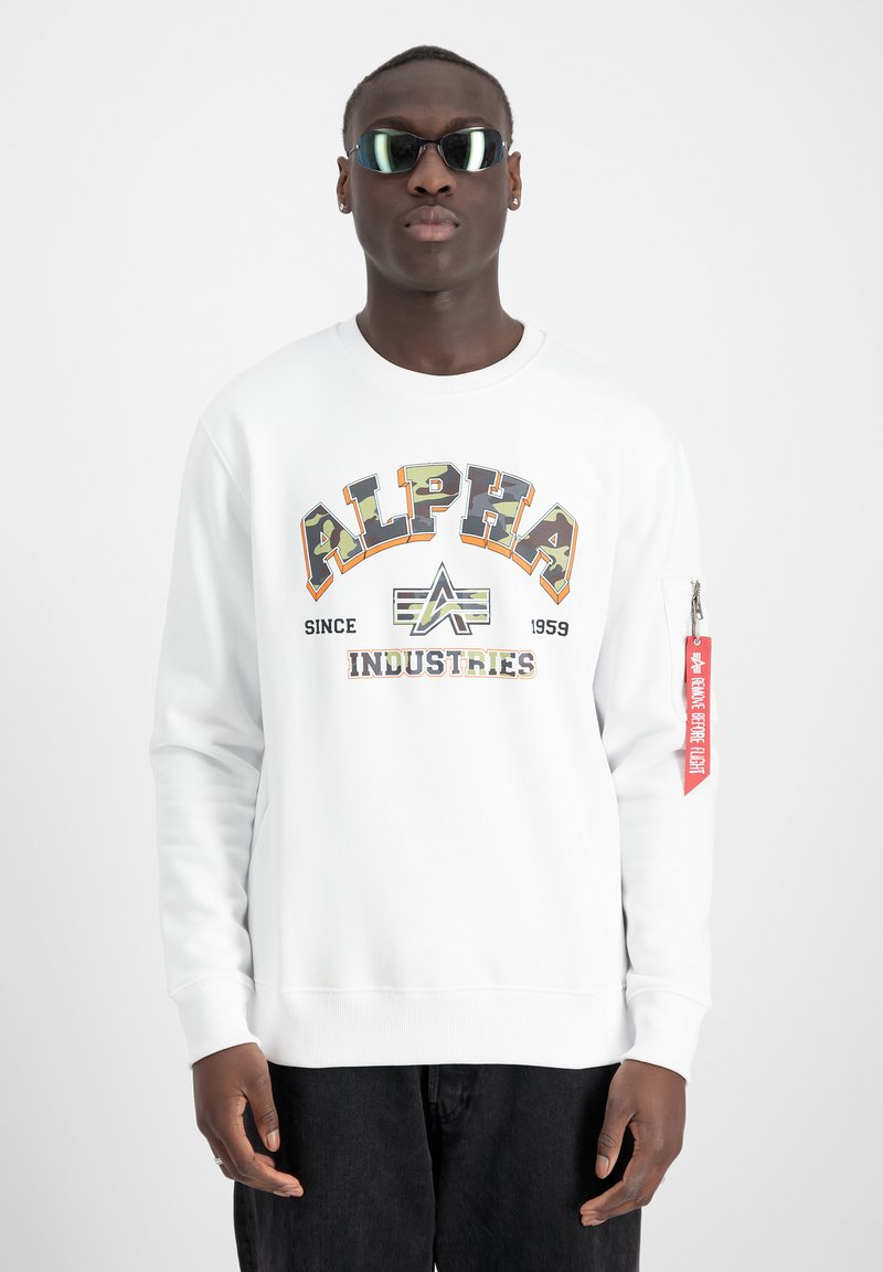 Felpa bianca con grafica "ALPHA INDUSTRIES" in multicolor, con colletto tondo e un'etichetta rossa con cerniera sulla manica.