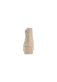 Stivali alti beige con piattaforma, realizzati in materiale sintetico testurizzato, foderati in pelliccia, con marchio in rilievo e suola spessa per un'altezza aggiuntiva.