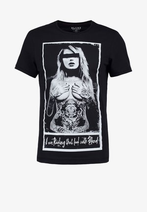 Czarny T-shirt z monochromatyczną grafiką przedstawiającą kobietę z tatuażami zakrywającą pierś, oczy zasłonięte, a poniżej tekst "I am Rocking that look with Blend".