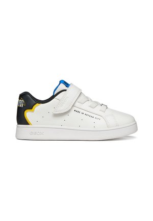 Sneaker bianca low-top con dettagli neri e gialli sul tallone, linguetta blu, cinturino in velcro, lacci e testo "Made in Gotham City" sul lato.