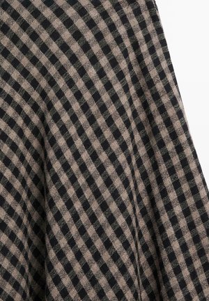 Zwart-beige geruit stof met een gestructureerd oppervlak, voorzien van een rasterpatroon van verschillende vierkanten op een zacht materiaal.